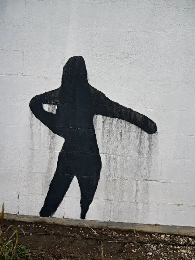 Black silhouette mural on a white wall